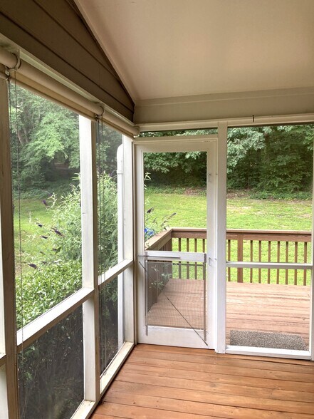 Screened porch opens to a sunny deck overlooking natural wooded area. - 1243 Cranebridge Pl