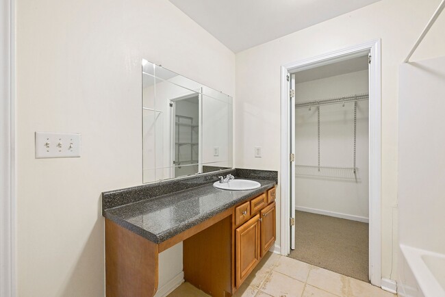 Expansive master bathroom featuring a large vanity and a generous walk-in closet, offering plenty of - 247 Farrington Ave SE