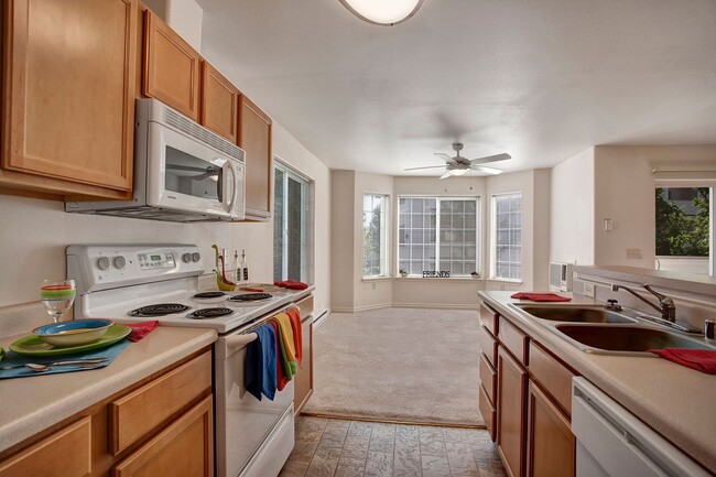 A kitchen with plenty of counter space, a breakfast bar, lots of cabinet storage space, and a view into the dining area - Lion's Gate