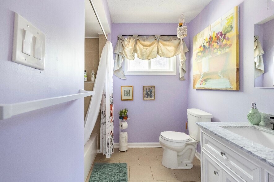 Full bathroom has natural light, new toilet and shower fixtures, and a tub - 1420 E Market St