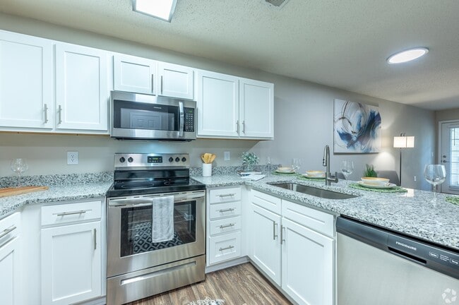 Kitchen with granite counters and stainless appliances - The Ashton