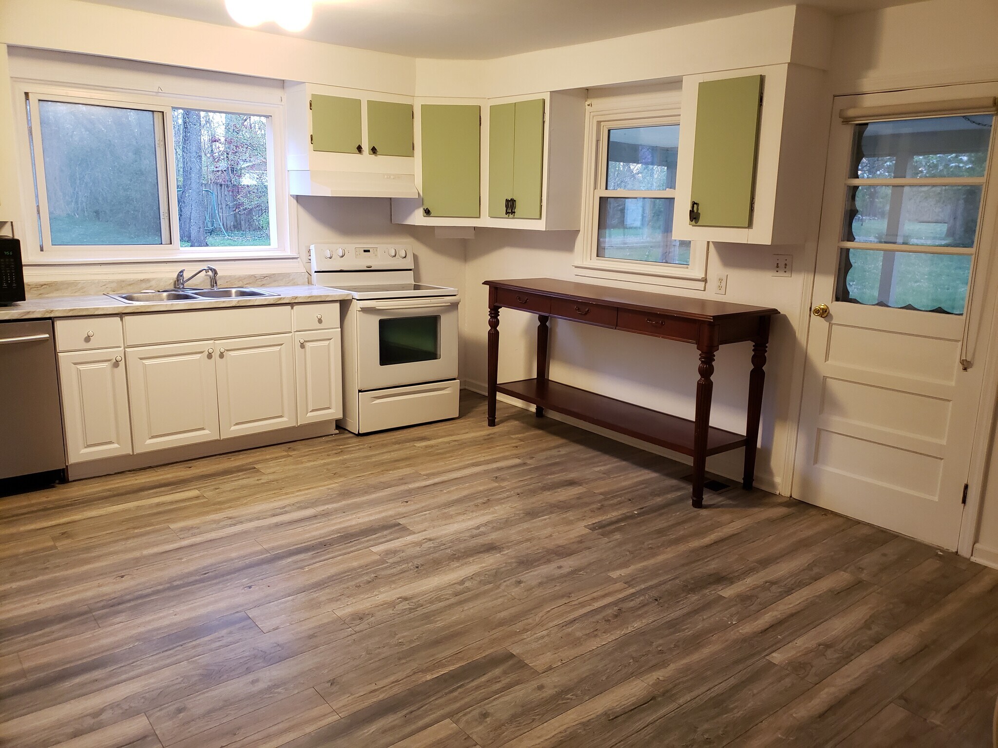 Large eat-in kitchen has vinyl flooring and door to the covered patio. - 10106 Wingfield Rd