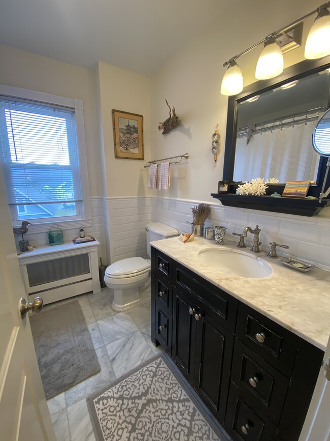 Marble tiled bath, large vanity, linen closet behind door to left - 381 Bedford Rd