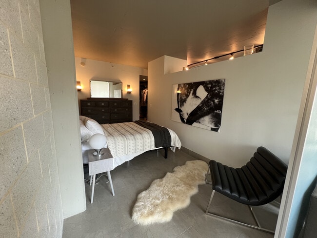 Bedroom with Restoration Hardware fur rug, accent chair and dresser. - 1133 14th St NW