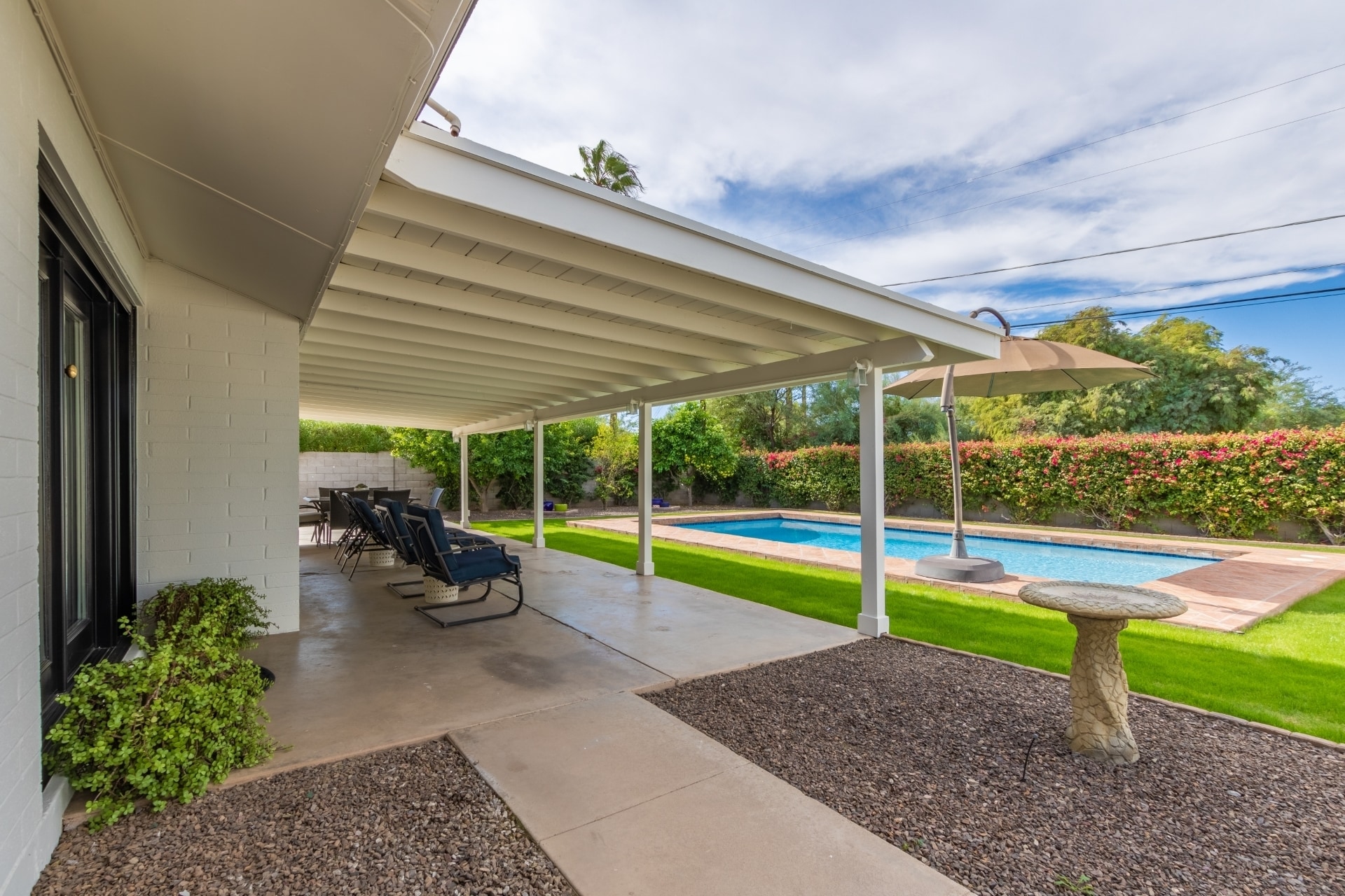 Large grass backyard has a covered patio and swimming pool. - 5214 N 43RD PL