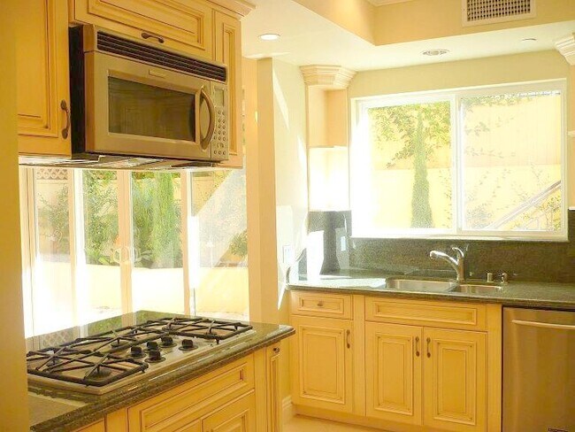 Kitchen open to dining / living area. Large window - 1540 S Bentley Ave