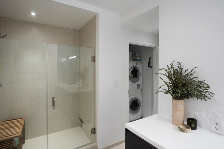 Stacked Bosch HE washer and dryer unit inside utility closet located in bathroom. - 2250 11th St NW