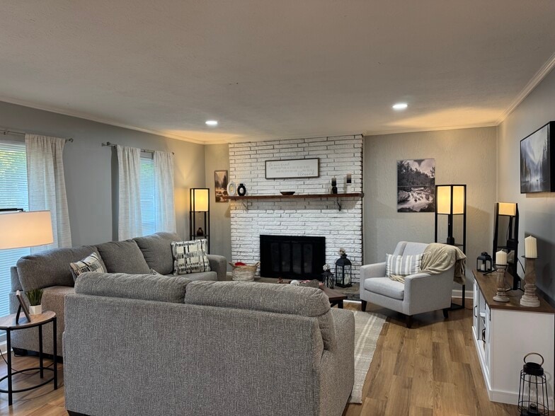 Spacious and fully furnished living room with cozy seating, smart TV, and natural light — perfect fo - 1117 Henrietta Dr