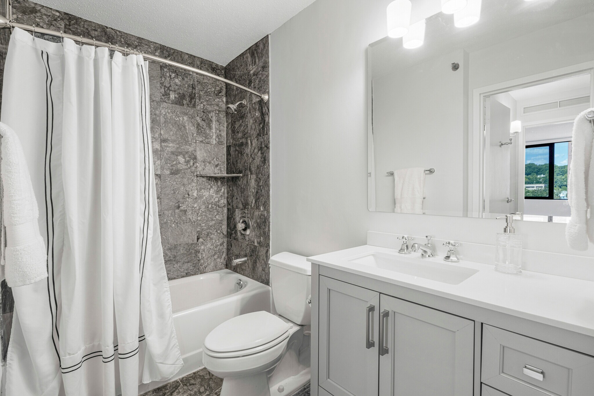 Modern classic vanity, mirror, lighting, curved shower rod, new W/D turn routine into retreat. - 4 Martine Ave