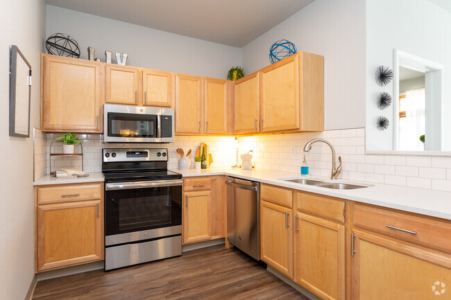 Gourmet kitchens with electric range, subway tile backsplash, and an island with breakfast bar. - Liv Arbors