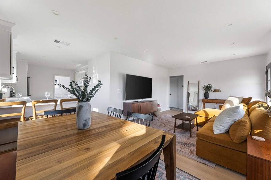 Living room with West Elm furniture, natural sunlight, and large TV flatscreen. - 1823 N Ditman Ave