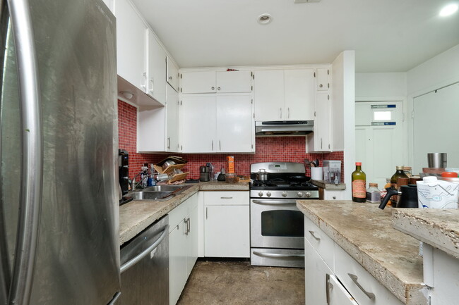 Kitchen detail, red tile and cement countertops. Gas range, stainless appliances - 1602 Valleyridge Dr