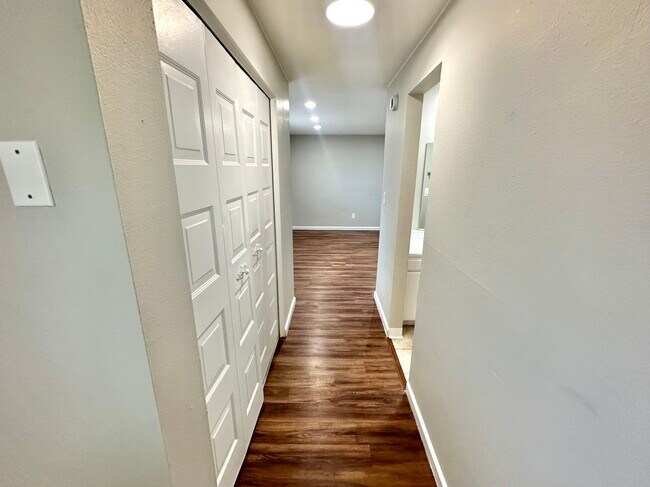 Step into this beautifully designed hallway with stylish wood flooring and crisp white accents. - Country Club
