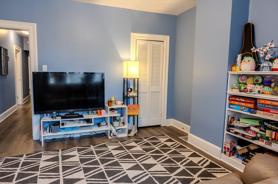 Enjoy this spacious living room with its built-in bookshelf and extra storage in the closet. - 1534 N Marshall St
