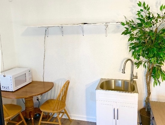 Microwave, kitchen sink, table and chairs, storage shelves, oven, refrigerator, W/D combo - 372 Chaucer Dr