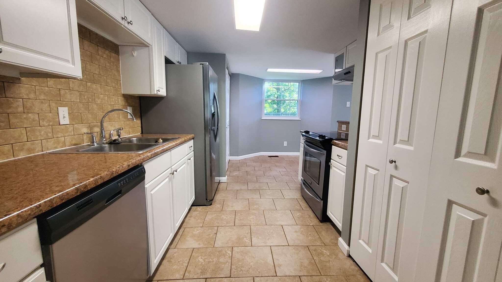 View from living room into kitchen. Pantry behind double doors on right. - 313 Britanna Dr