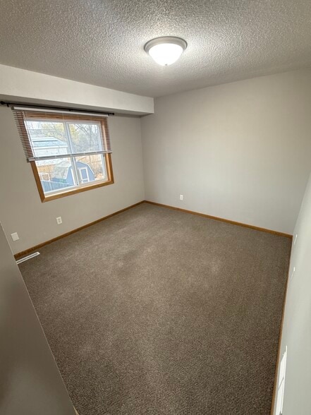 Bright upper-level bedroom with natural light and standard closet. - 9092 Goldenrod Ln N