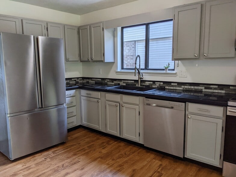 Kitchen with refrigerator, dishwasher and stove - 1649 Summerhill Dr