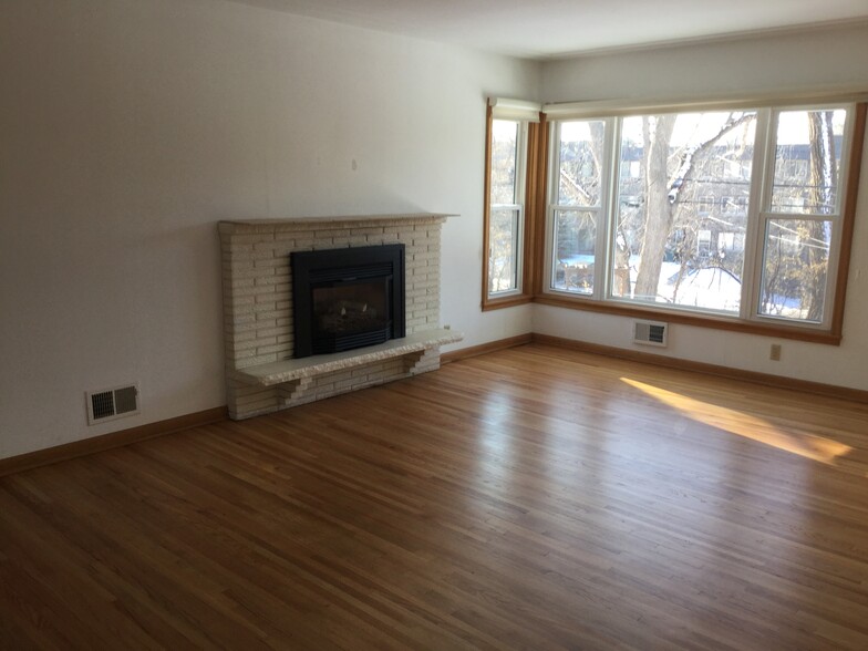 Light filled living room with freshly refinished hardwood floors and gas fireplace - 5206 Grandview Ln