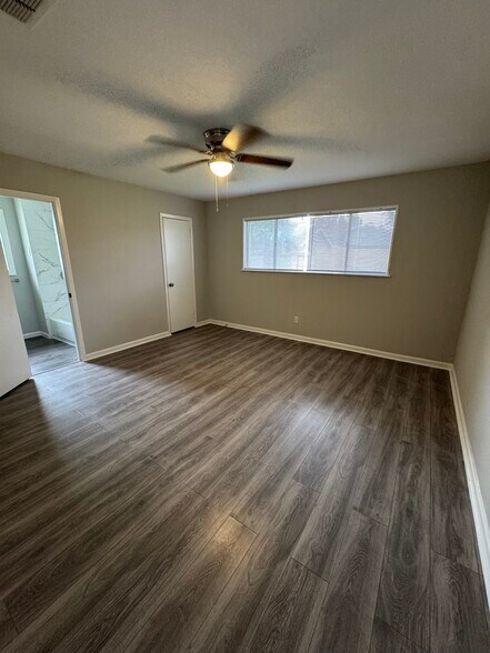 Bright and cozy master bedroom with large windows and neutral tones throughout. - 11927 Troulon Dr