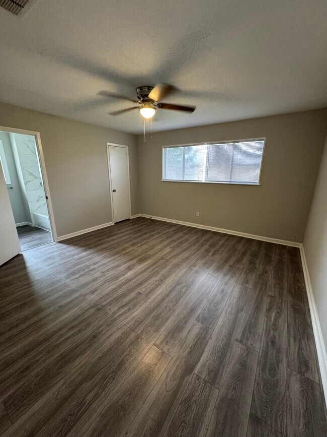 Bright and cozy master bedroom with large windows and neutral tones throughout. - 11927 Troulon Dr