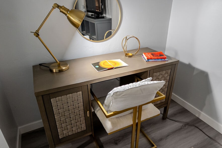 A cozy workspace featuring a comfortable chair and a warm lamp for focused work. - 4989 Randlett Dr