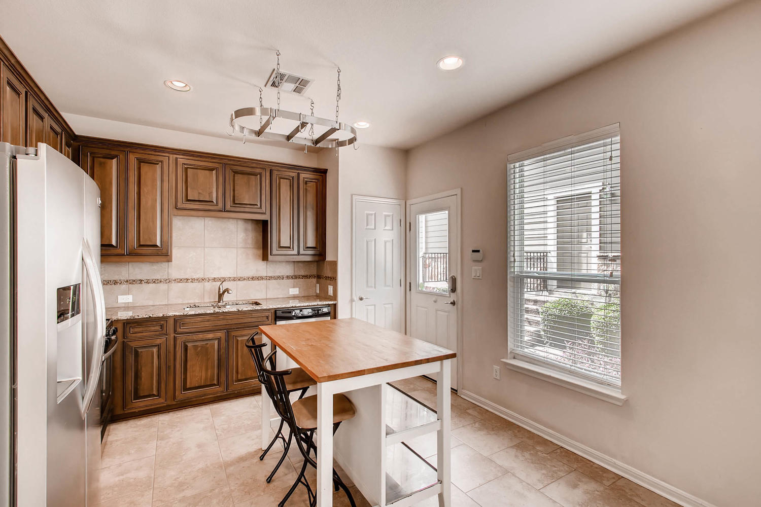 Kitchen island with a pot rack on the ceiling for modern decor and functional use! - 1813 Carlson Drive