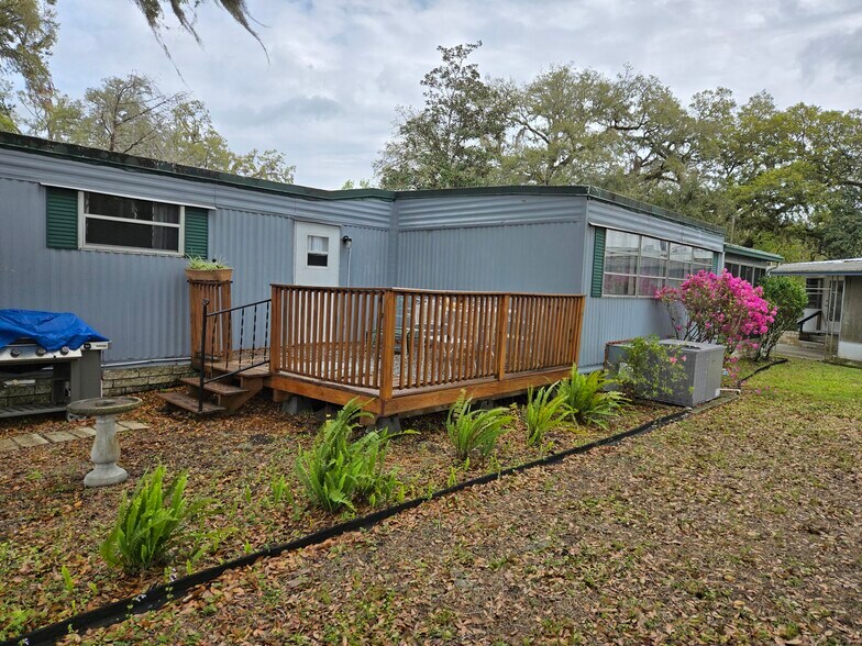 Deck in back yard with a door. - 1204 Crest Ct