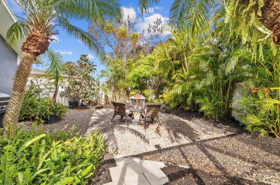 Private, fenced yard surrounded by palms and peaceful garden vibes. - 1932 Brainerd Ct