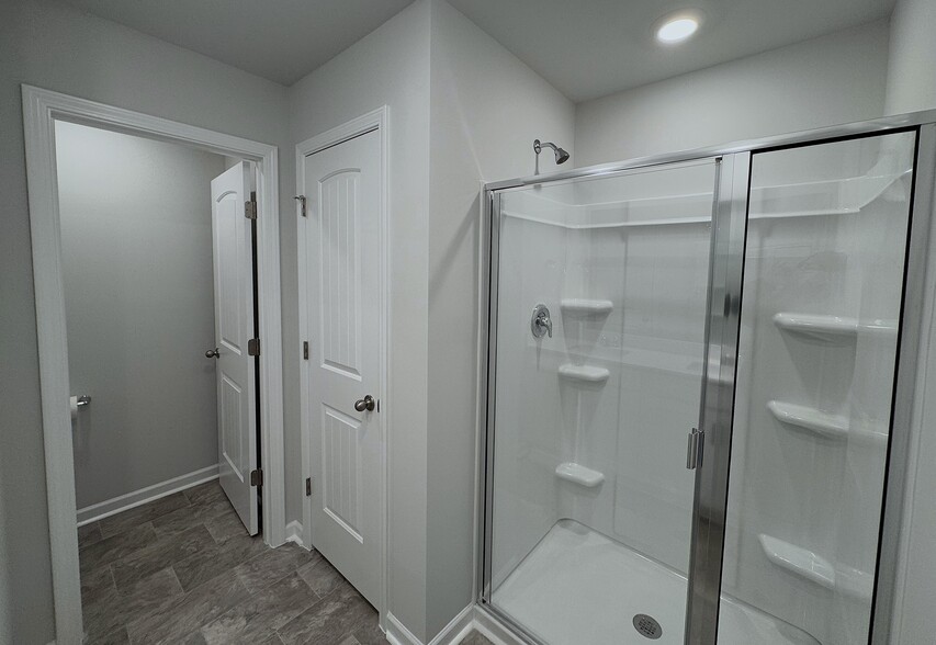 The master bathroom has a large shower, a linen closet, and a separate toilet space. - 403 Augustine Dr