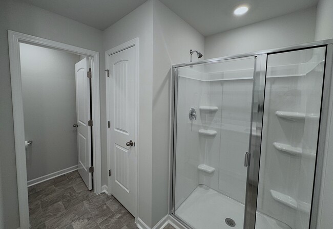 The master bathroom has a large shower, a linen closet, and a separate toilet space. - 403 Augustine Dr