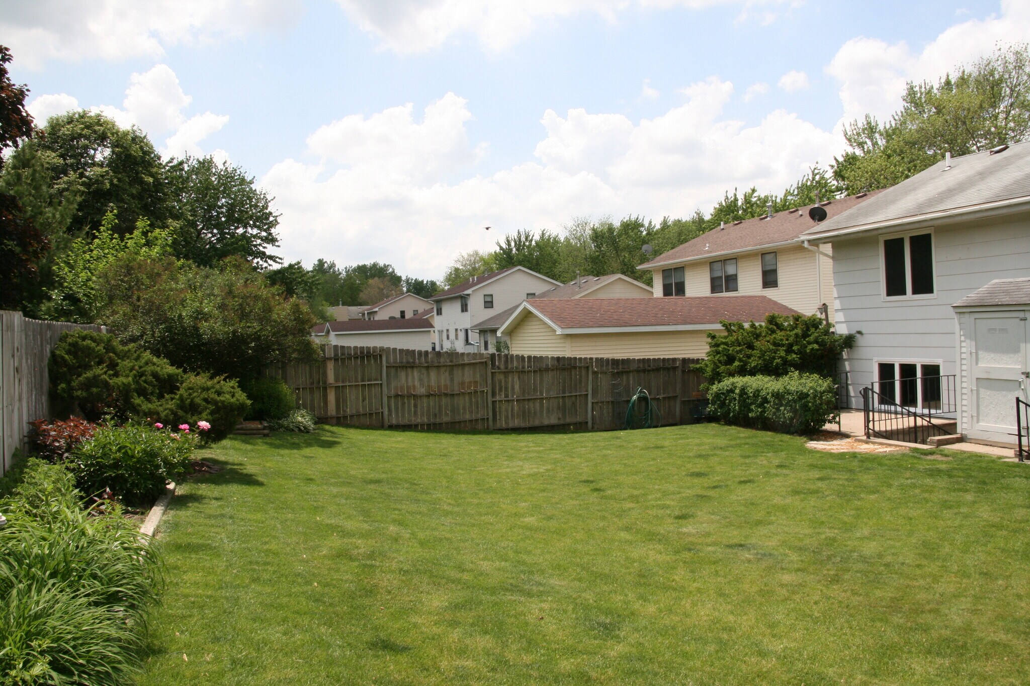 Fenced back yard in a previous summer - 4527 51st St