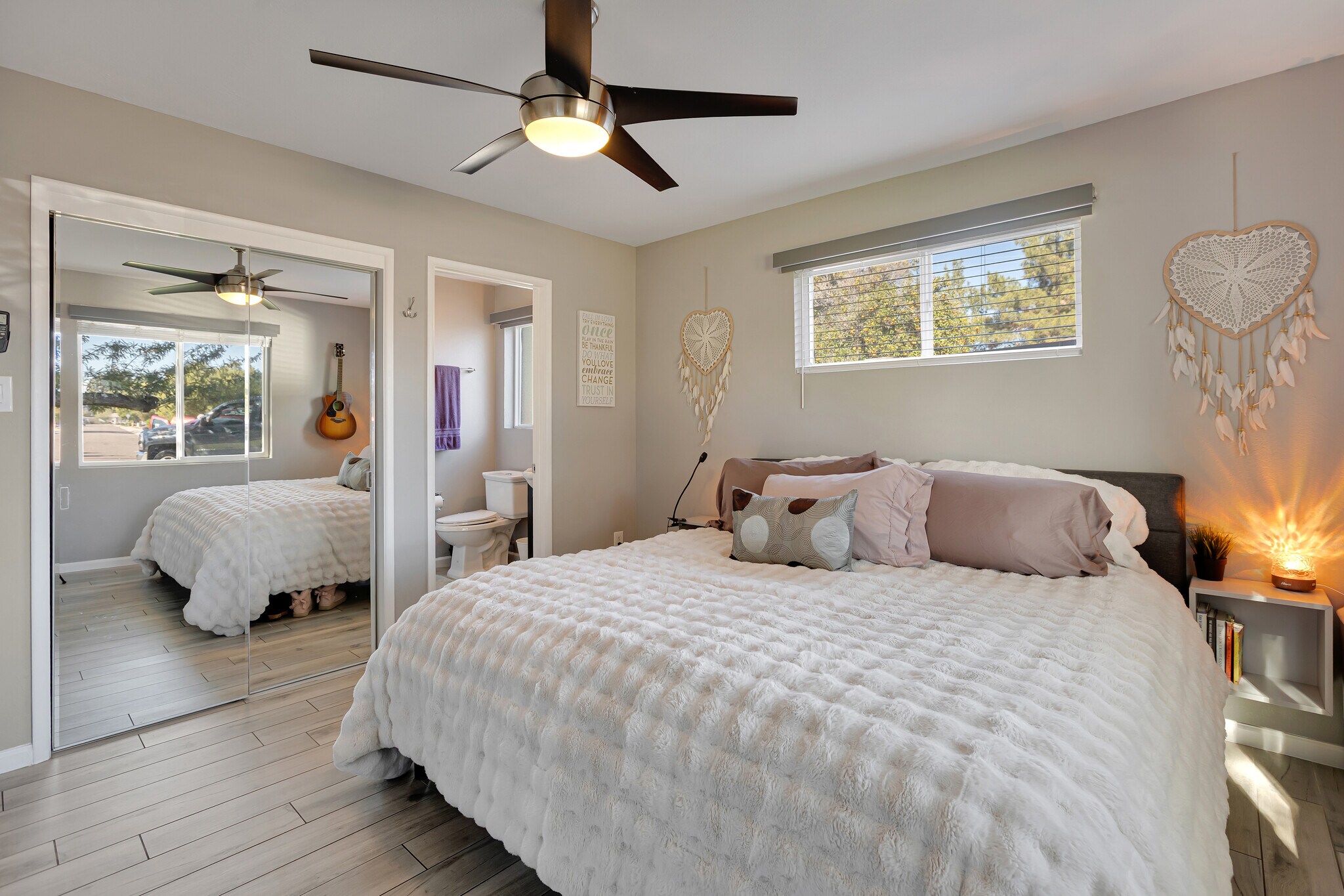 Primary bedroom featuring a king bed, natural light, and peaceful sunrise views - 6136 N 9th St