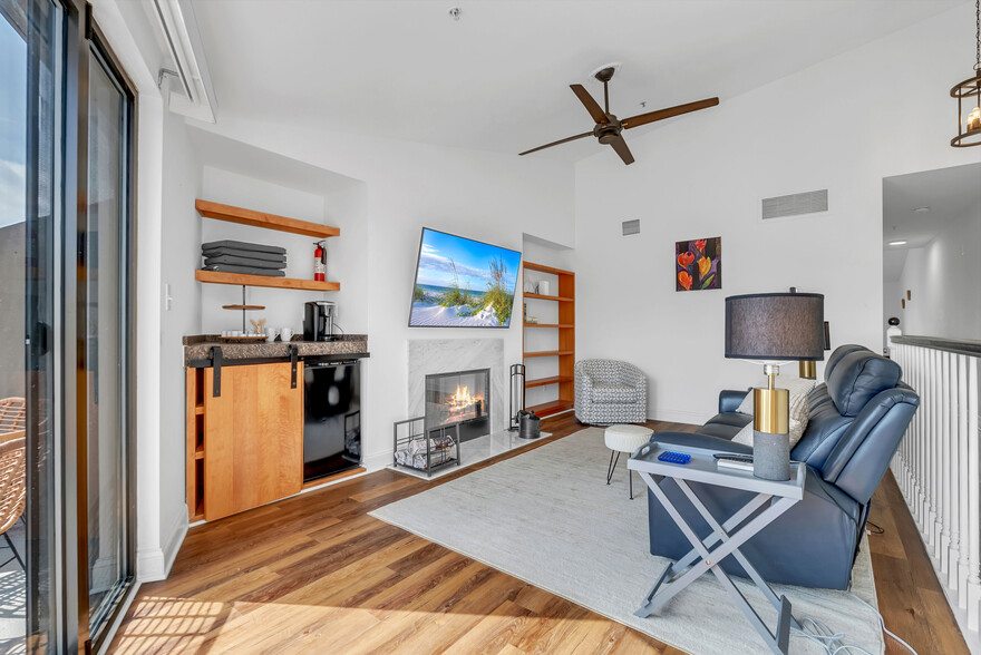 Upstairs living room with wood burning fireplace, mini-fridge and flat screen TV. - 1000 Fell St