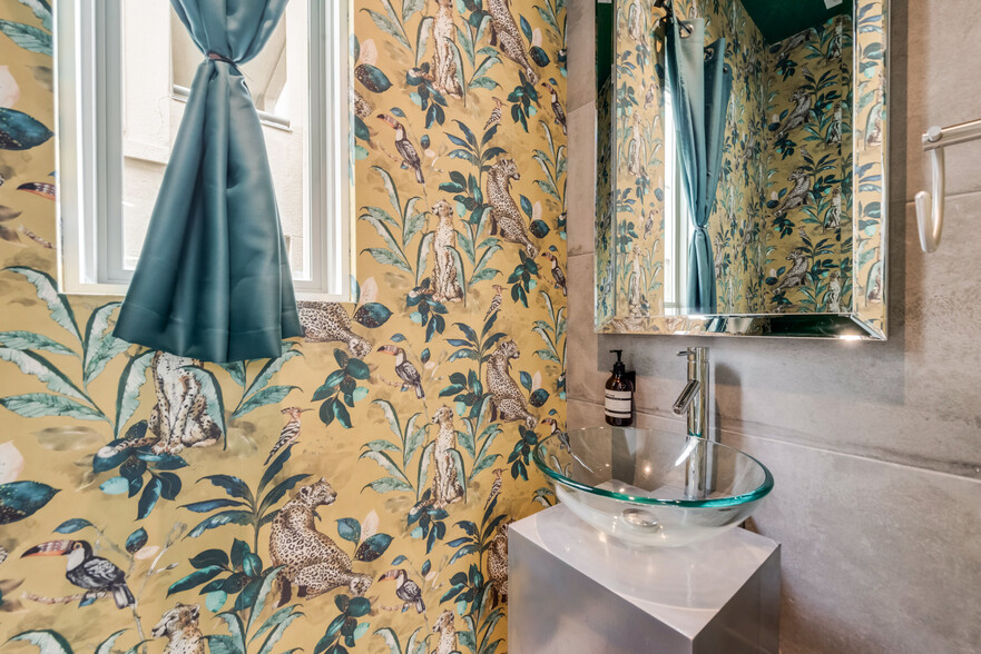 Artsy wallpaper enriches the convenient half bath accessible from the living area. - 4434 Holland Ave