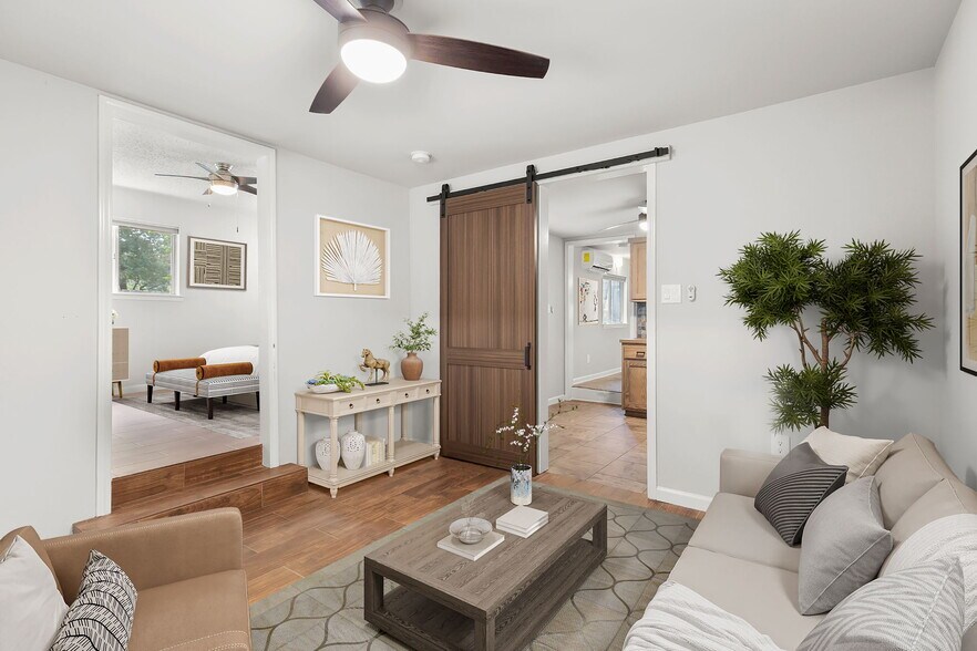 Sunken living space with new tile flooring, fans, and barn door - 815 Gunter St