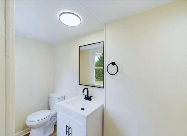 Bathroom: The vanity features a sleek black faucet and a large rectangular mirror. - 1011 Elm St