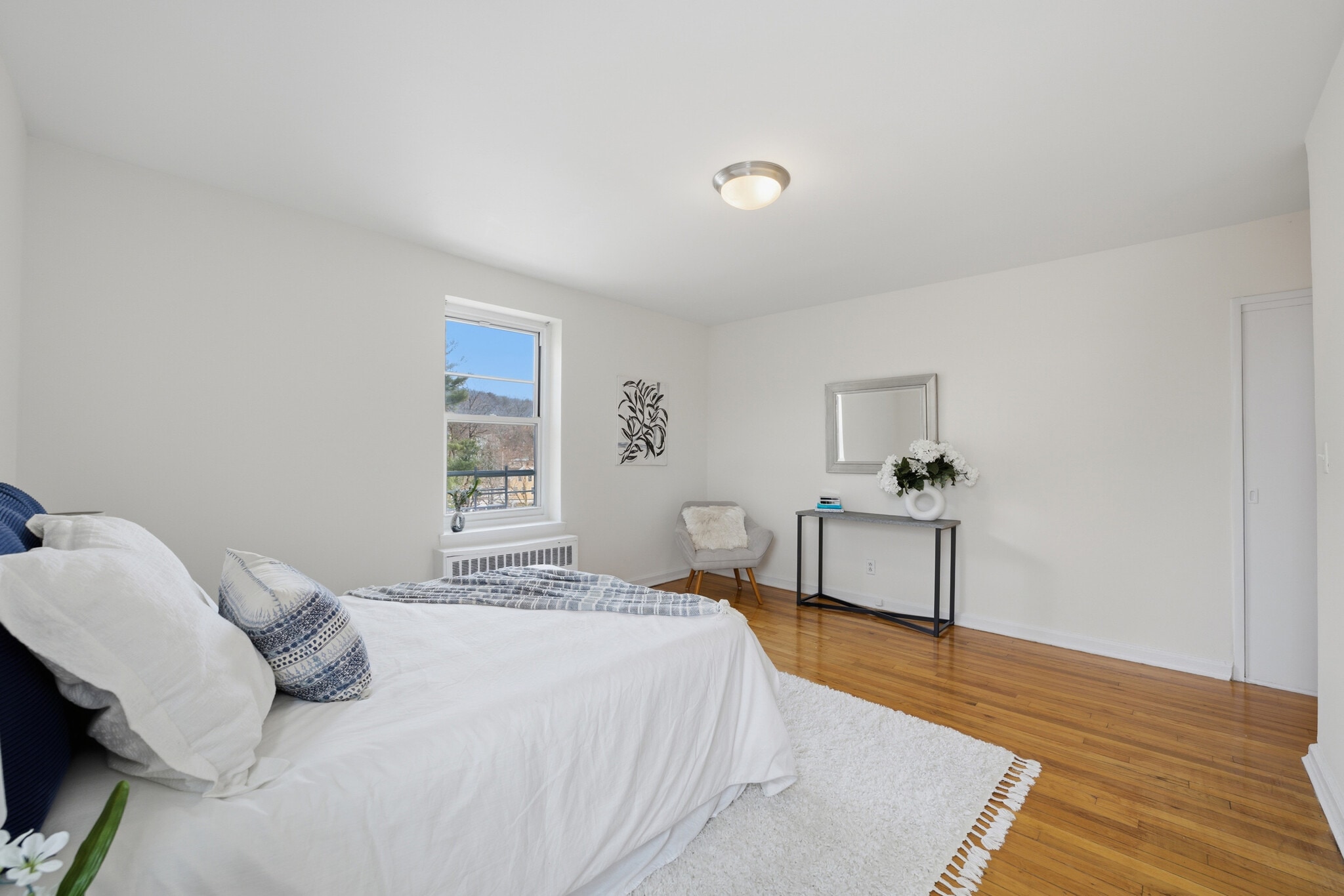 Spacious primary bedroom with two windows, including one overlooking the Hudson River. - 555 Broadway