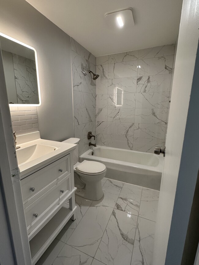 Recently renovated full bath with luxury amenities such as marble tub surround, marble floors, etc - 1082H Mount Hope Ave