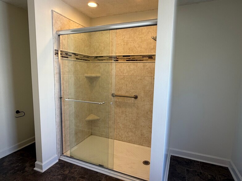 Beautifully tiled walk-in shower with glass doors - 6419 Woodmont Rd