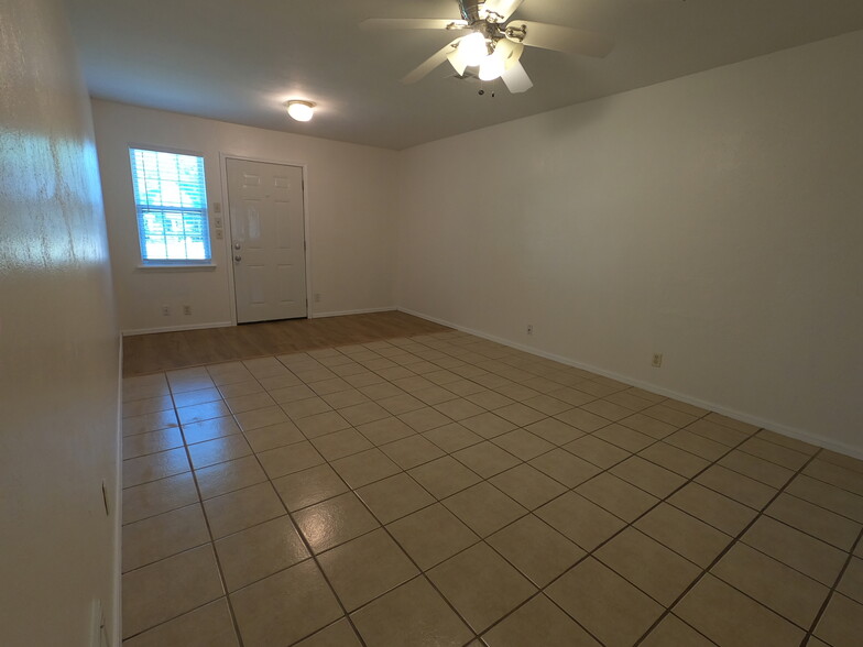 View of living room facing front door with wood floor entryway - 415 W Guthrie St