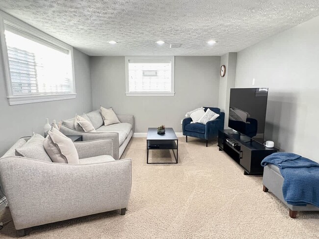 Cozy entertainment sitting area with a 65 inch HD Smart TV. - 1237 Giesse Dr