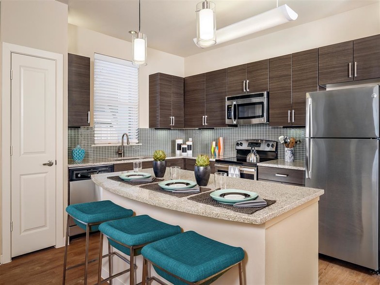 Kitchen with granite countertops, stainless steel appliances, wood-style floors, and modern lighting over island - Thirty Oaks