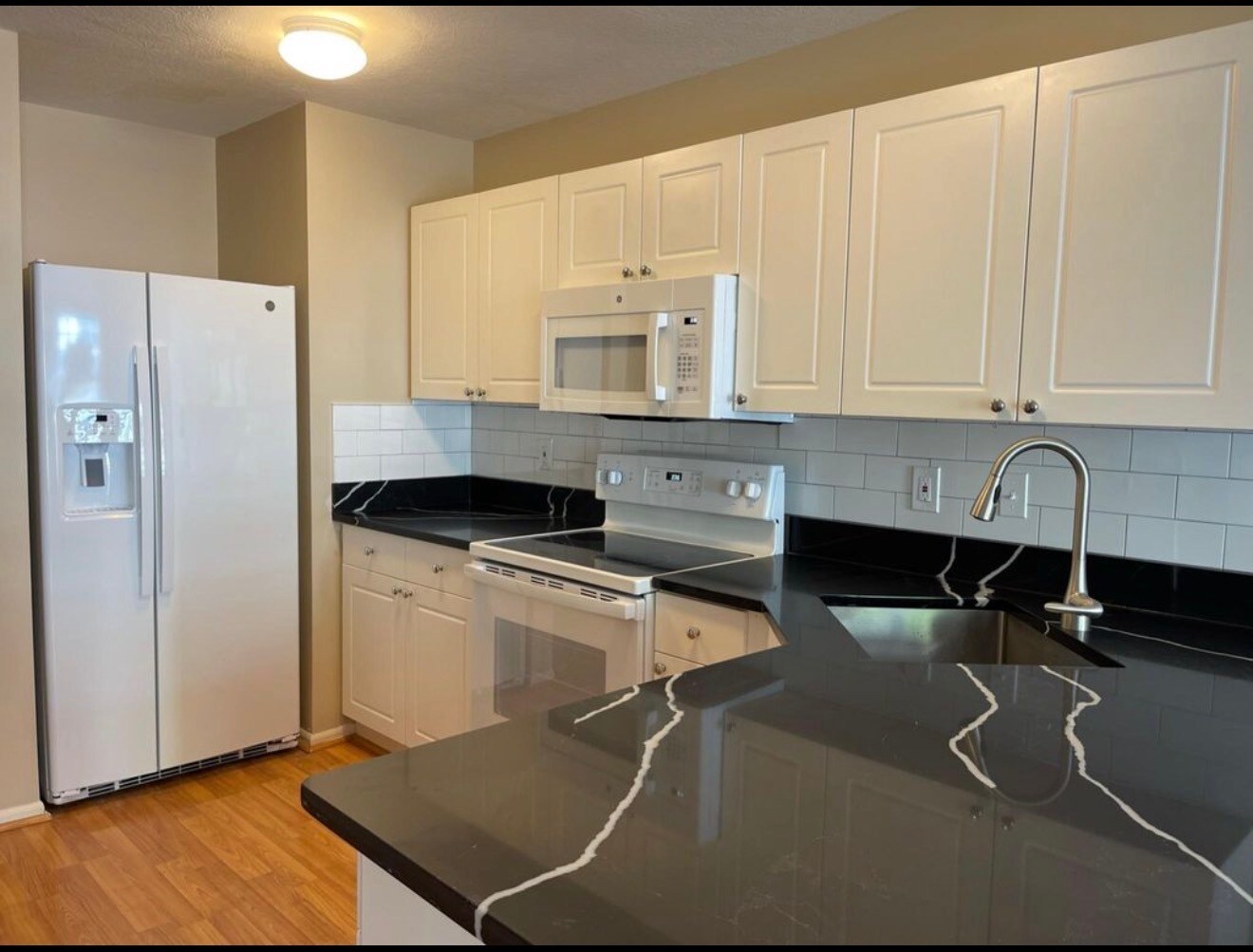 Updated kitchen with white cabinetry, subway tile backsplash, and modern quartz countertops. - 289 Preswicke Ml