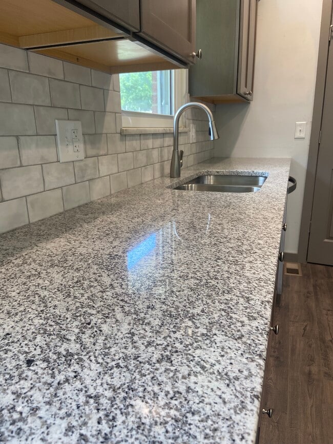 Remodeled Kitchen with granite counters, tile backsplash, and new appliances - 174 Brisbane Ave