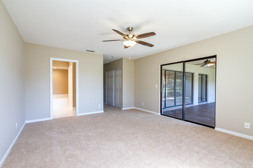 Master bedroom with sliding door leading to large screened patio - 8555 Eagle Run Dr