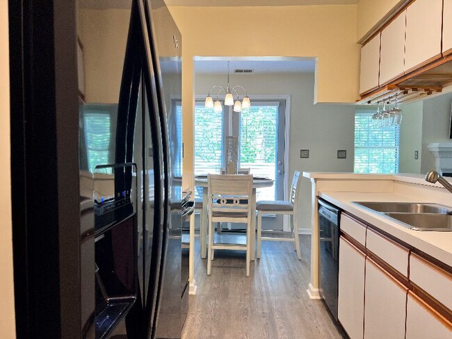 Kitchen view from washer/dryer area to dinette and balcony. - 704 Rapidan River Ct