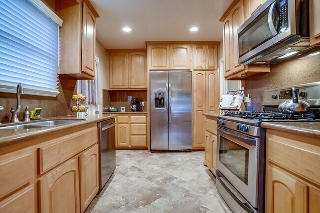 Kitchen with custom cabinetry, granite counters, natural stone flooring - 1340 W 3rd St