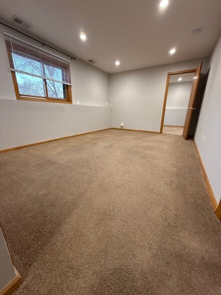 Large lower-level living room with oversized window and fresh carpeting. - 9092 Goldenrod Ln N
