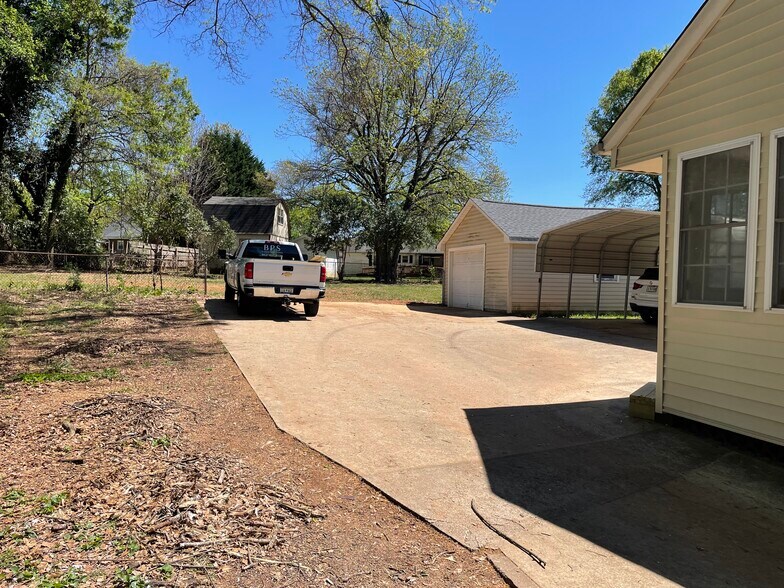 Large driveway with a carport and electric garage door - 205 N Beacon St